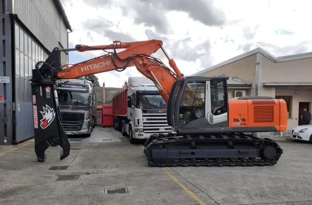 Carico rottami con escavatore ragno – Ser Sider Escavatore con ragno carica rottami metallici su camion in area industriale