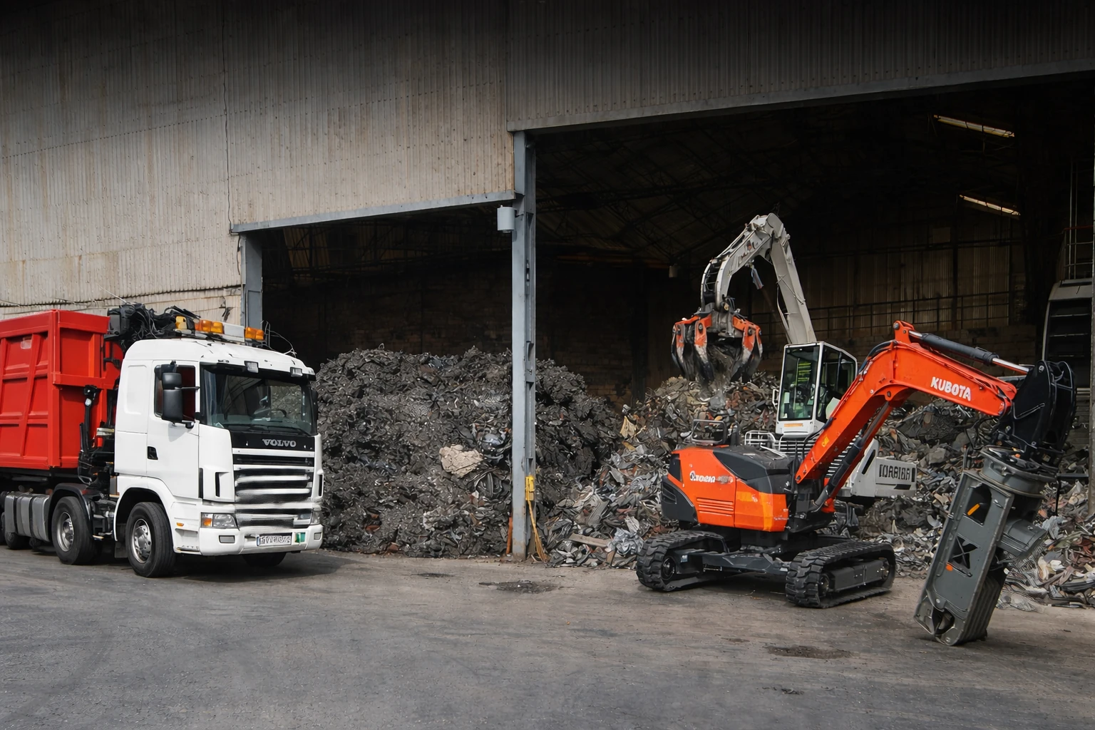 Camion e escavatore con ragno per il recupero rottami metallici in capannone industriale